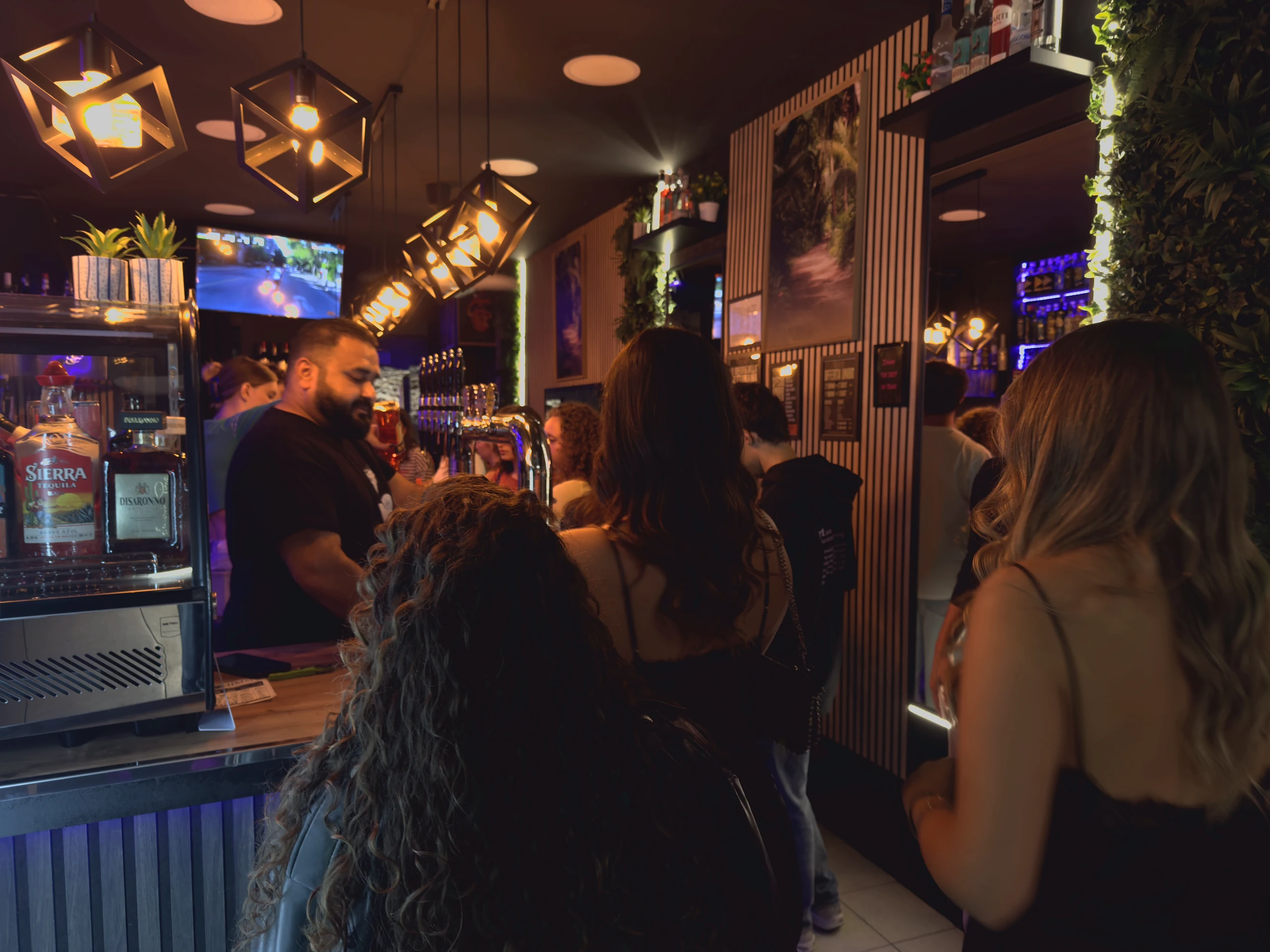 Bartender e ospiti al bancone affollato del Jimmy.