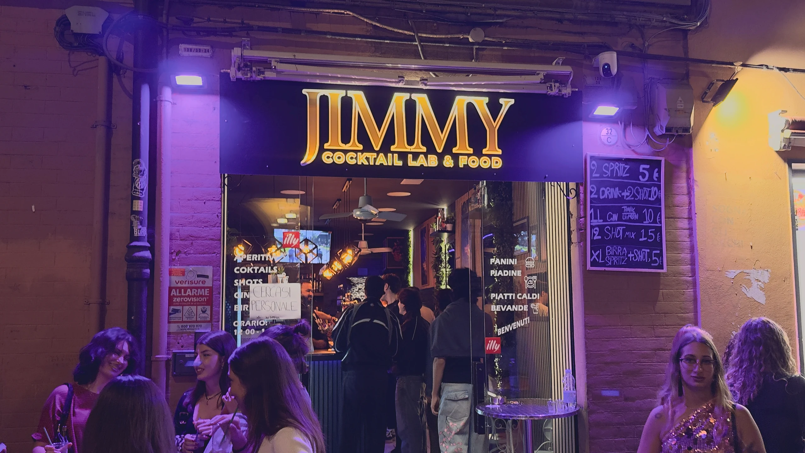 L'insegna di Jimmy e persone all'esterno del locale.