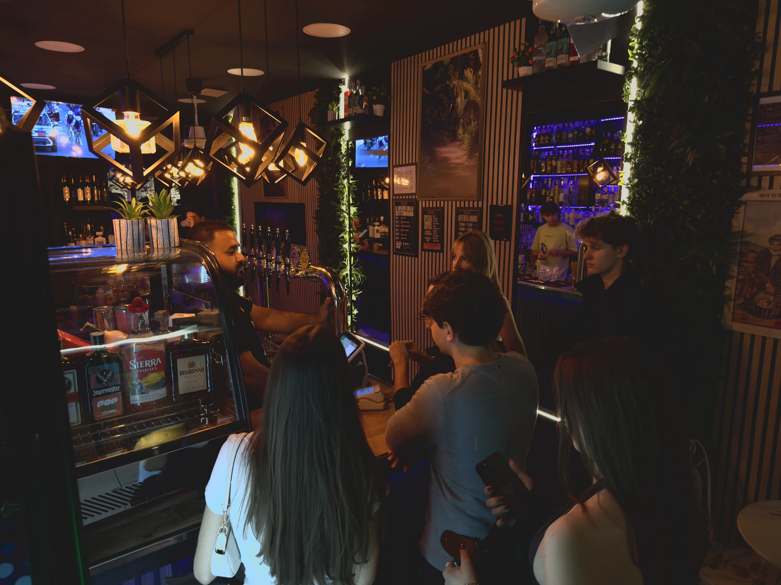 Il bartender serve gli ospiti al bancone.
